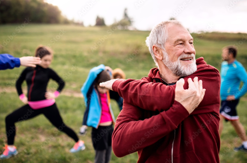 The Right Kind of Exercise for Wellness and Health: How Much is Enough? 8 Large group of fit and active people doing exercise in nature, stretching.