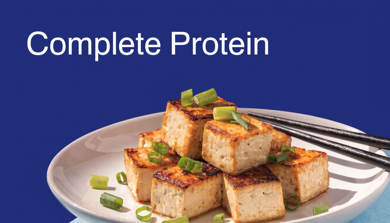 10 Top High Protein Vegetarian Foods for 2026 2 A close-up of golden pan-fried tofu cubes garnished with fresh green onions on a white plate.